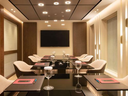 a conference room with tables and chairs and a flat screen tv at Sofitel Athens Airport in Athens