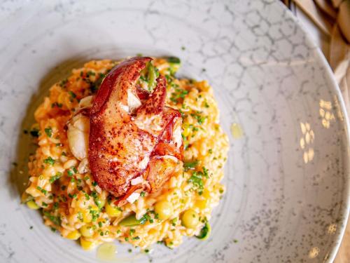 a bowl of food with a piece of bacon on pasta at Sofitel Lafayette Square Washington DC in Washington