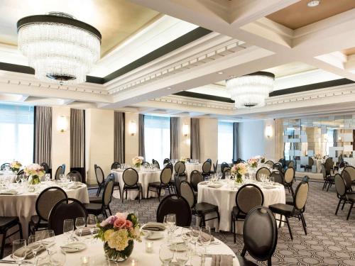 a banquet hall with white tables and chairs and chandeliers at Sofitel Lafayette Square Washington DC in Washington