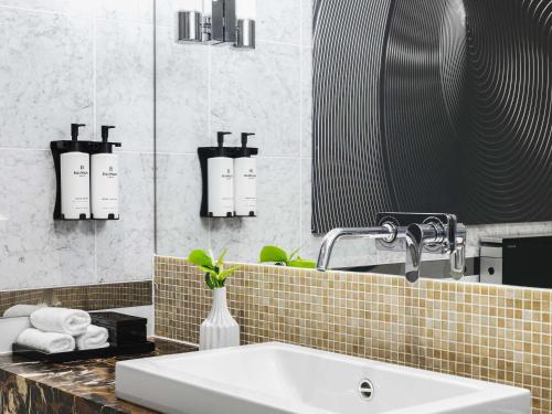 a bathroom with a sink and a mirror at Sofitel Warsaw Victoria in Warsaw