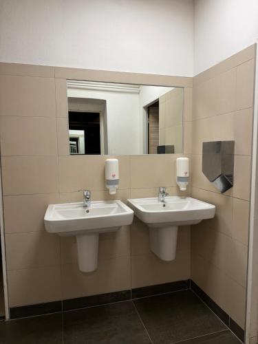 une salle de bain avec deux lavabos et un miroir dans l'établissement Urban SPA Loft, à Golčŭv Jeníkov