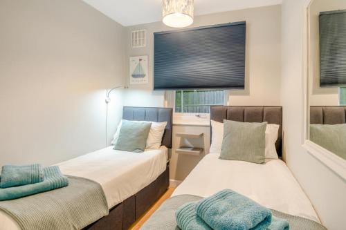 a bedroom with two beds and a window at Whistles in Weybourne