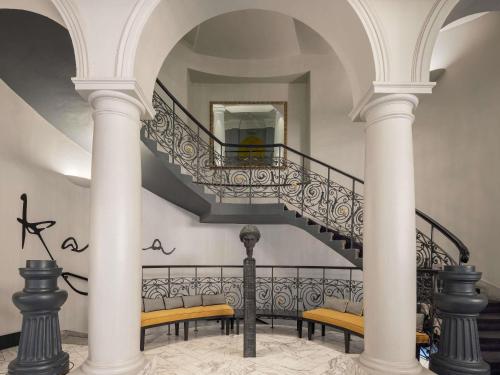 a staircase with columns and benches in a building at Century Old Town Prague - MGallery Collection in Prague
