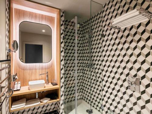 a bathroom with a shower and a sink and a mirror at Century Old Town Prague - MGallery Collection in Prague