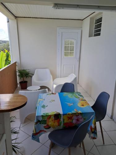 a room with a table and chairs on a balcony at Studio du PARADIS in Le Marin