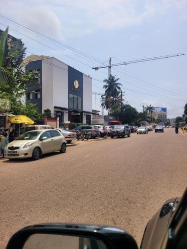 a street with cars parked on the side of the road at Résidence Cosy en plein centre ville d'Akwa in Douala