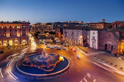 a city with a fountain in the middle of a street at Anantara Palazzo Naiadi Rome Hotel - A Leading Hotel of the World in Rome