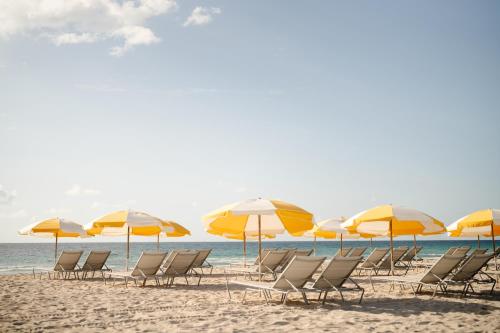 a group of chairs and umbrellas on a beach at Balfour Miami Beach, a Morgans Originals hotel in Miami Beach