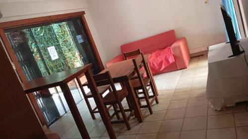 a room with a table and chairs and a couch at Hostel La Bodega in Encarnación