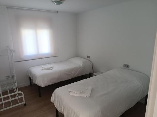 a room with two beds and a window at Apartamento Nayara in Alcañiz