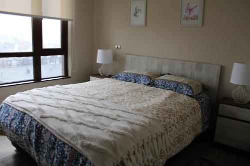 a bedroom with a large bed and a window at MPHB203 Departamento para 3 personas con Vista a Lago in Puerto Varas