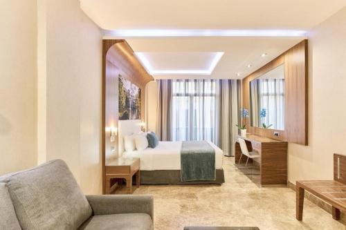 a hotel room with a bed and a couch at VP Jardín de Recoletos in Madrid