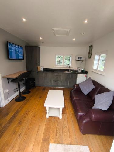 a living room with a couch and a table at The Pumphouse with Hot Tub in Weymouth