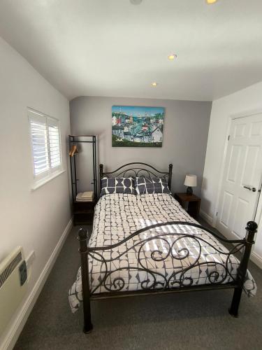 a bedroom with a bed with a metal frame at The Pumphouse with Hot Tub in Weymouth