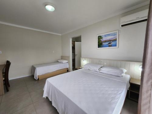 Una habitación de hotel con dos camas y una ventana. en Bomar Residence, en Bombinhas