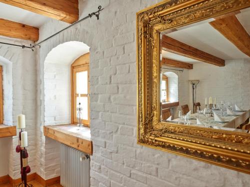 un grand miroir doré sur un mur de briques dans une pièce dans l'établissement Historisches Bauernhaus mit Show-Küche & Kamin, à Fürstenzell