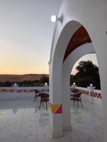 an arch with chairs and tables on a patio at Reagan House in Aswan