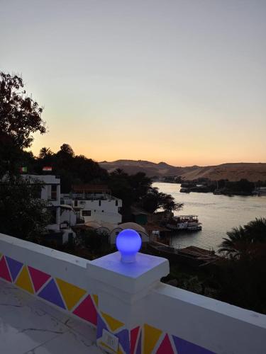 a blue vase sitting on a white railing overlooking a river at Reagan House in Aswan