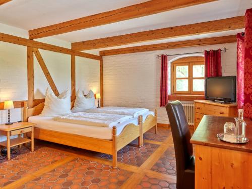 une chambre avec un lit et une télévision dans une pièce dans l'établissement Historisches Bauernhaus mit Show-Küche & Kamin, à Fürstenzell