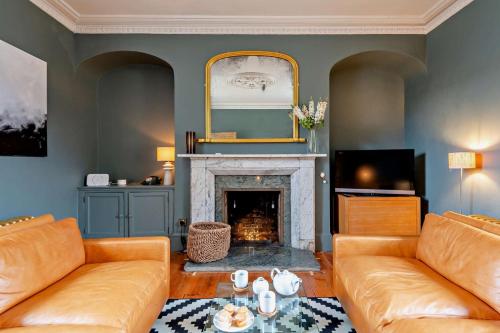 a living room with two couches and a fireplace at Red House in Methwold