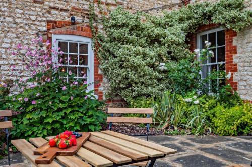 a wooden bench with flowers on it in front of a building at Red House in Methwold