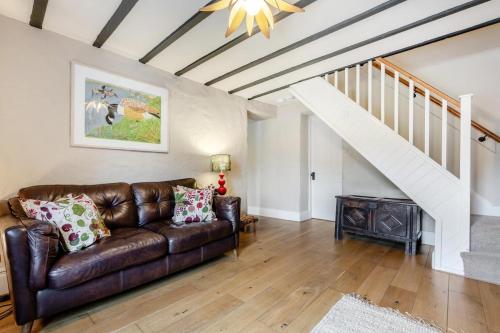 a living room with a leather couch and stairs at Hill View in Appersett
