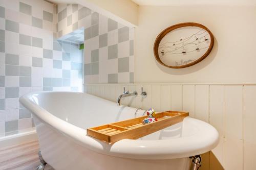 a bath tub in a bathroom with a clock on the wall at Hill View in Appersett