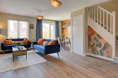 a living room with blue couches and a staircase at Marriott House sleeps 5 in Bourne with parking in Bourne