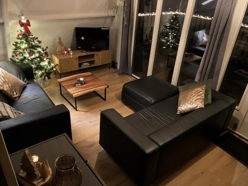 - un salon avec un arbre de Noël et un canapé dans l'établissement Chalet Tournesol Durbuy, à Durbuy