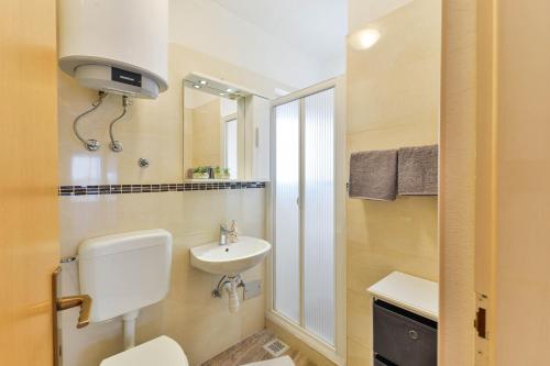 a bathroom with a toilet and a sink at Apartmani LUNA in Vir