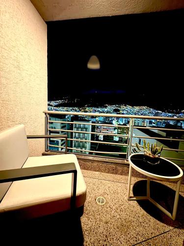 a balcony with a tv and a chair and a table at Olympus Apartments in Quito
