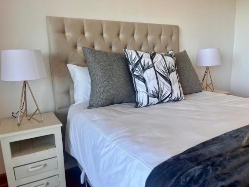 a bedroom with a large bed with two lamps at Bo-den-See Guesthouse in Groot Brak Rivier