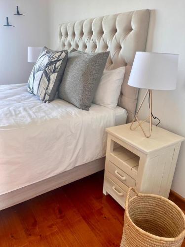 a bed with pillows and a night stand with a lamp at Bo-den-See Guesthouse in Groot Brak Rivier