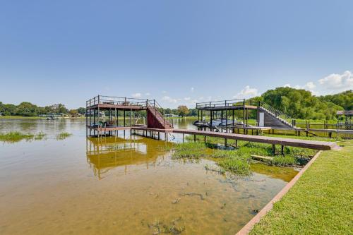 a dock in the water next to a river at Lakefront Escape with Game Room and Dock in Mabank! in Enchanted Oaks