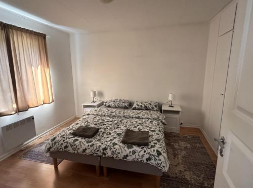 a white bedroom with a bed and two lamps at Koselig 3 roms leilighet på Rjukan in Øverland