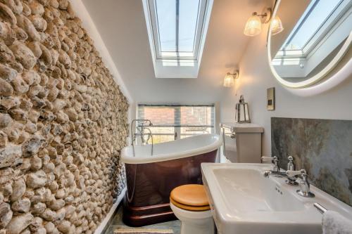 une salle de bains avec lavabo, baignoire et toilettes dans l'établissement Golden Goose Cottage, à Wiveton