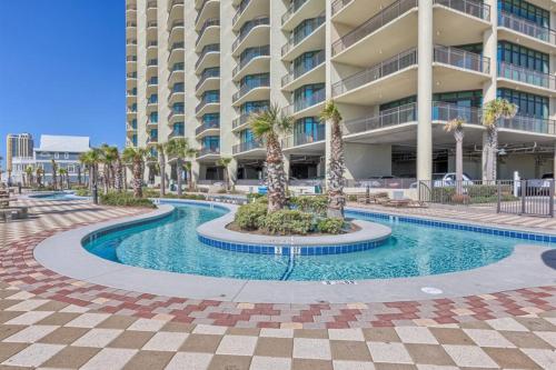 a swimming pool in front of a large building at Phoenix West 2601 in Orange Beach