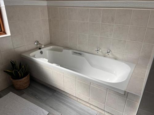 a large white bath tub in a bathroom at Bo-den-See Guesthouse in Groot Brak Rivier