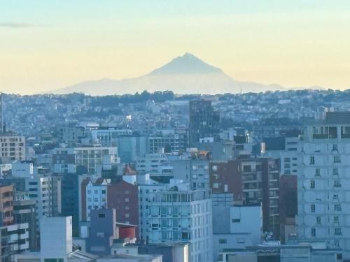 a view of a city with a mountain in the background at Olympus Apartments in Quito