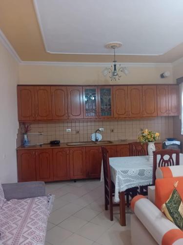 kuchnia z drewnianymi szafkami, stołem i kanapą w obiekcie Villa Gimi w Gjirokastrze