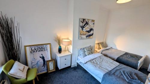 a small bedroom with two beds and a chair at The road to Wigan Pier in Pemberton