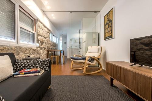 a living room with a couch and a television at An apartment with a view - Nó's place in Vila Nova de Gaia