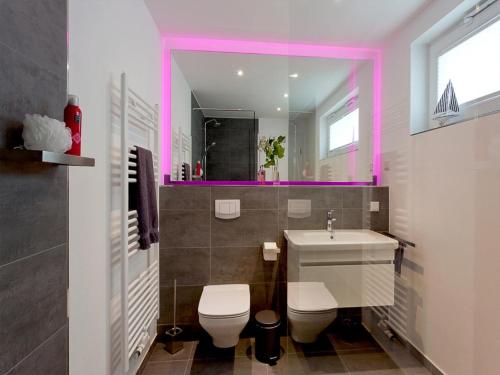 a bathroom with a toilet and a sink and a mirror at Ferienhaus am Yachthafen in Peenemünde in Peenemünde