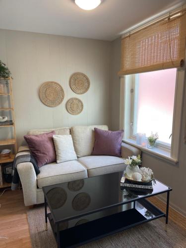 a living room with a couch and a coffee table at Midt i byen in Trondheim