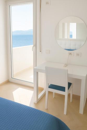 a bedroom with a white desk and a mirror and a window at White Residence Apartament in Sarandë