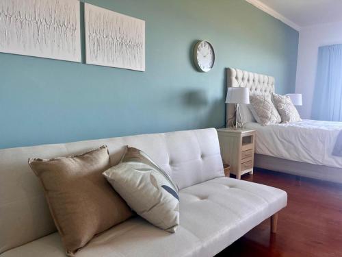 a living room with a white couch and a bed at Bo-den-See Guesthouse in Groot Brak Rivier