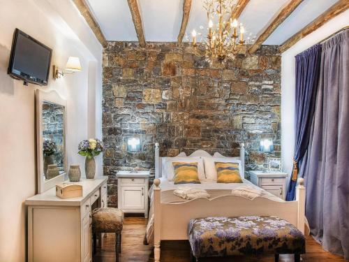 a bedroom with a bed and a stone wall at Home with Garden & Pool for All in Pemónia