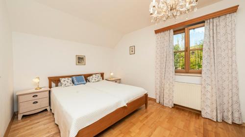 a bedroom with a bed and a window at Haus Seegarten - LANDLUFT in Grundlsee