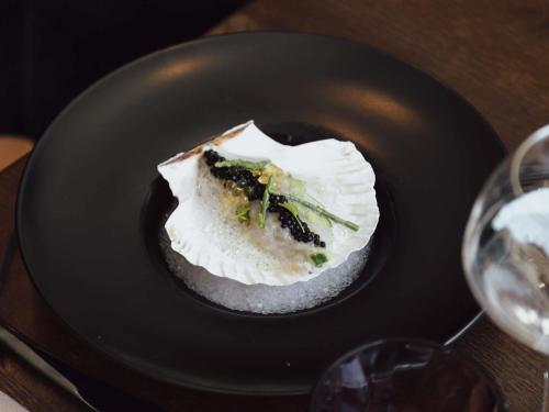 a piece of food on a plate with a glass of wine at Sofitel Brussels Europe in Brussels
