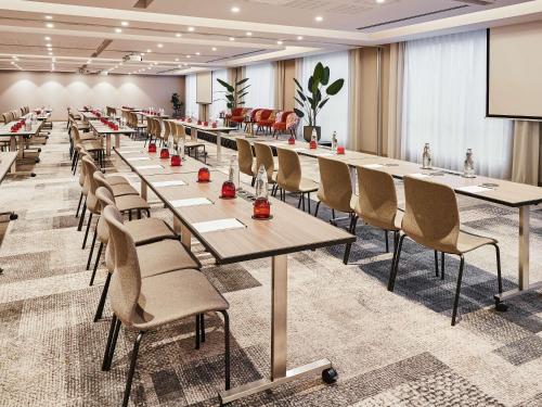 a conference room with tables and chairs and a projection screen at Sofitel Brussels Europe in Brussels